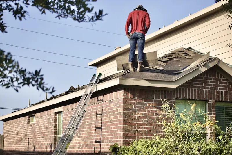 Professional roofer working on a residential roof in Harvey